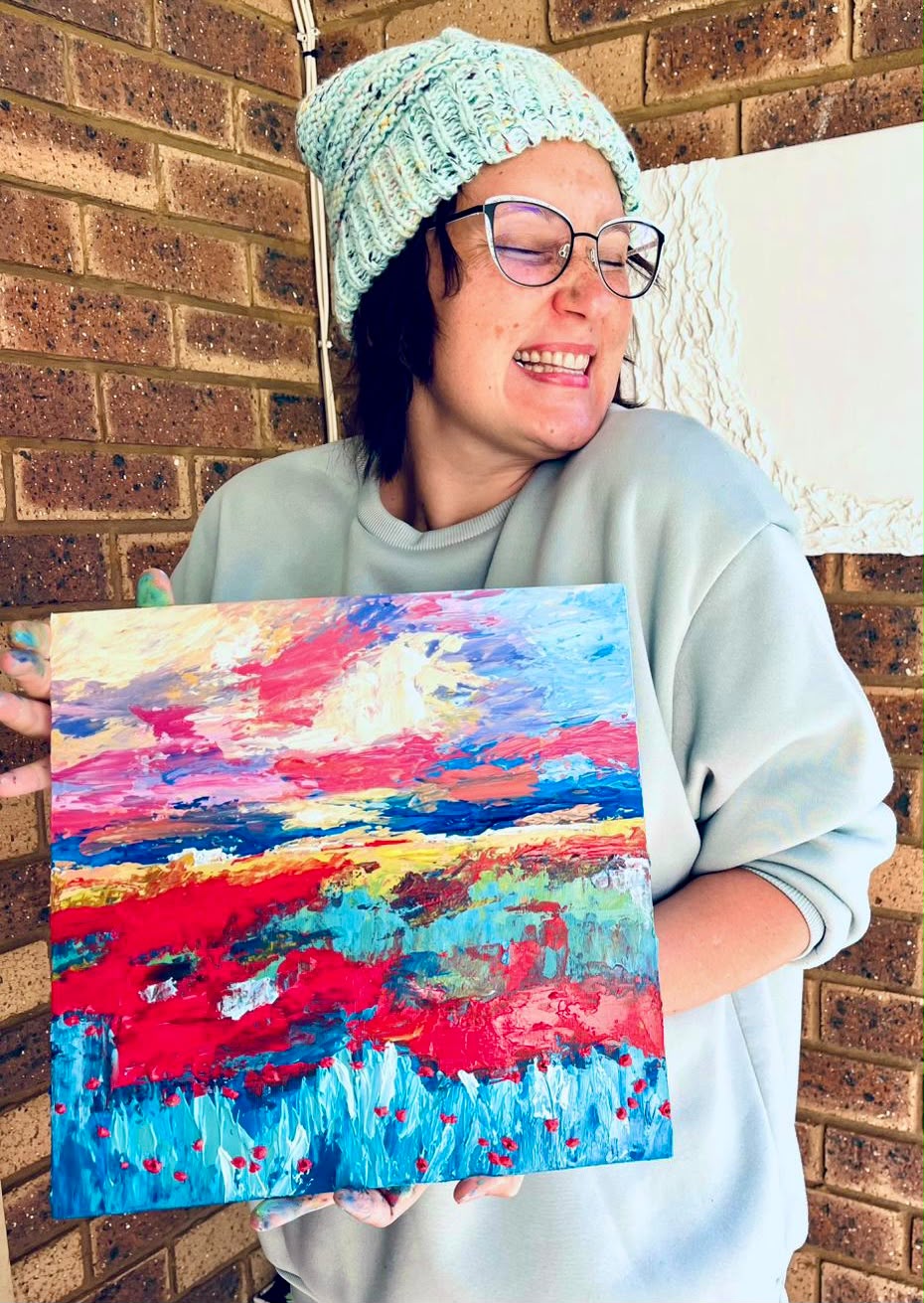 CrazeeArtsee founder painting a vibrant canvas in her studio